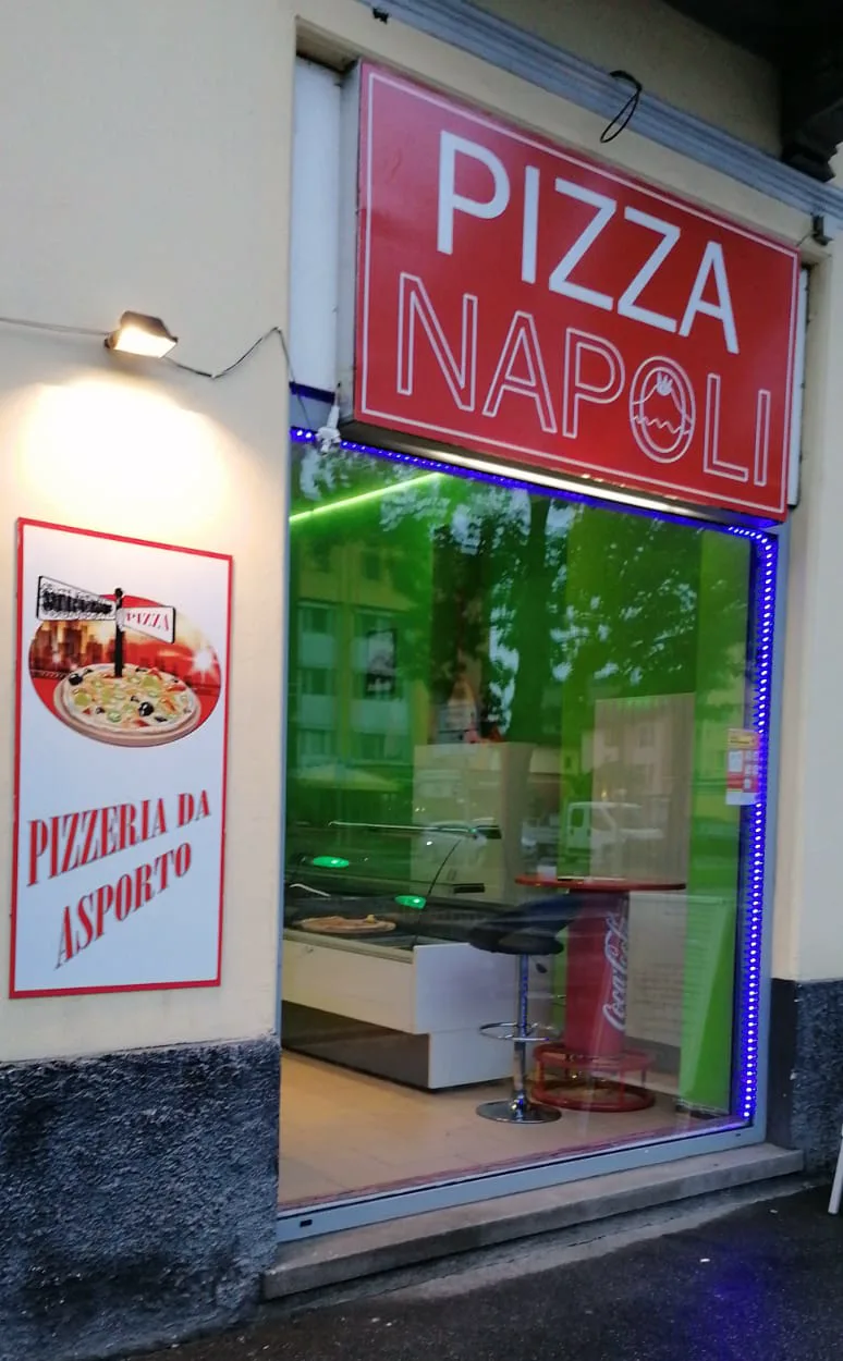 L'ingresso di Pizza Napoli a Bellinzona con l'insegna rossa e la vetrina illuminata